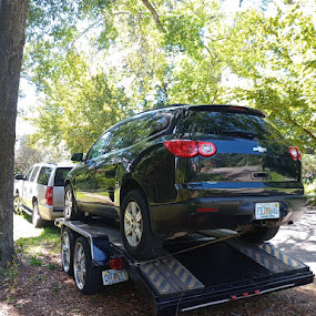 SUV loaded on a towing trailer being transported in Gainesville, FL