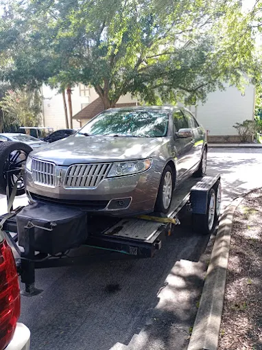 Sedan loaded and strapped onto a towing trailer in Gainesville, FL