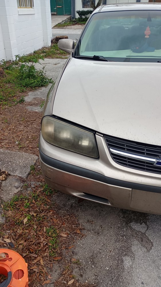 Foggy, oxidized vehicle headlight before headlight restoring service